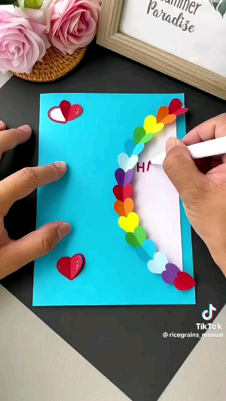 someone is making a card with hearts on it