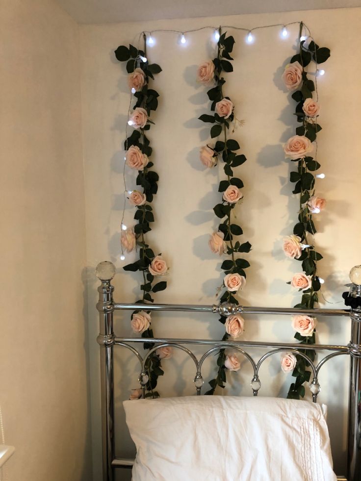 there is a bed with flowers on the headboard and lights strung from the wall