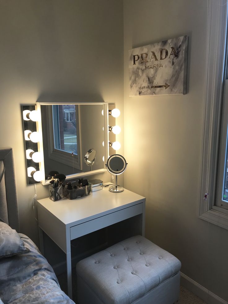 a bedroom with a vanity, stool and mirror on the wall in front of it