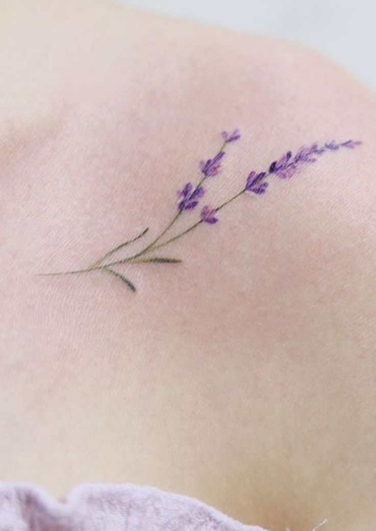 the back of a woman's shoulder with lavender flowers on it