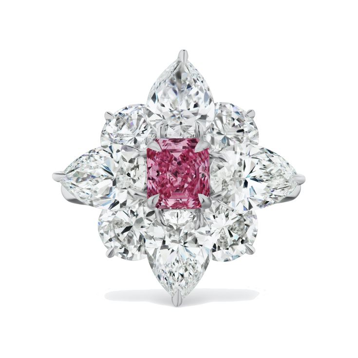 A spectacular diamond deserves a dramatic setting. This breathtaking ring displays an array of flawless pear and round diamonds arranged to resemble flower petals, surrounding a sensational, radiant-cut Argyle Pink diamond center. Sure to become a heirloom piece, the color and clarity of the stones are unmatched. 1.04CT Radiant Cut Fancy Intense Purplish Pink Diamond (5P) - SI2 Clarity, GIA# 2215086282 8 x 0.88CT Pear Shape and Round Natural White Diamonds (7CT) - D Color, IF Clarity, GIA Certif Flawless Diamond Ring, Coloured Diamonds, Argyle Pink Diamonds, Pink Diamond Ring, Argyle Diamonds, Flawless Diamond, Round Diamond Setting, High Jewellery, Halo Pendant