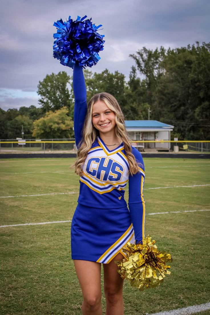 a cheerleader is holding her pom - poms in the air