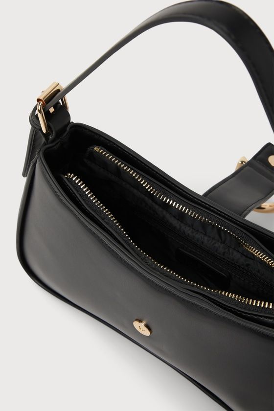 The Lulus Oh-So Chic Black Buckle Shoulder Bag was made for every girl-on-the-go! Smooth faux leather shapes this ultra-chic handbag with a structured design and an adjustable shoulder strap. A wide strap with an oversized buckle detail and a hidden magnetic closure lifts to reveal a zippered top that opens up to a lined interior with a sidewall pouch and zippered pocket. Gold hardware throughout creates an elevated look! Lined. Bag Measures 10. 5" Wide, 6" Tall, And 2" Deep. Adjustable Shoulder Evening Satchel Baguette Bag With Zipper Closure, Chic Faux Leather Baguette Bag With Double Handle, Faux Leather Shoulder Bag With Adjustable Top Handle, Faux Leather Shoulder Bag With Adjustable Handle, Trendy Crossbody Baguette Bag For Formal Occasions, Modern Faux Leather Baguette Bag With Zipper, Chic Faux Leather Baguette Bag For Evening, Office Baguette Bag With Zipper Closure And Double Handle, Office Baguette Bag With Zipper And Double Handle