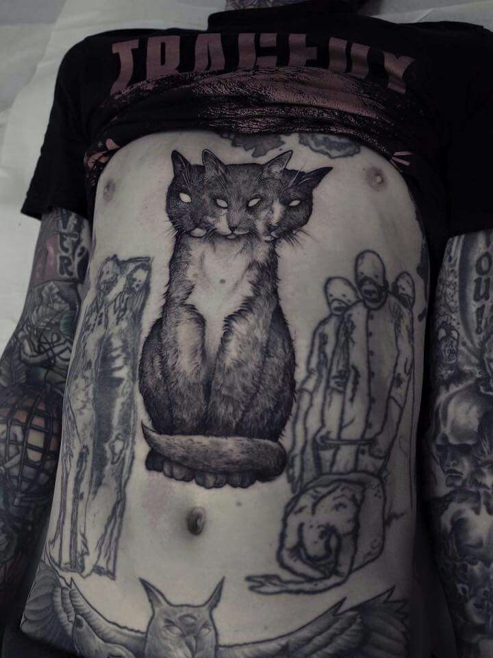 a cat tattoo on the side of a woman's stomach