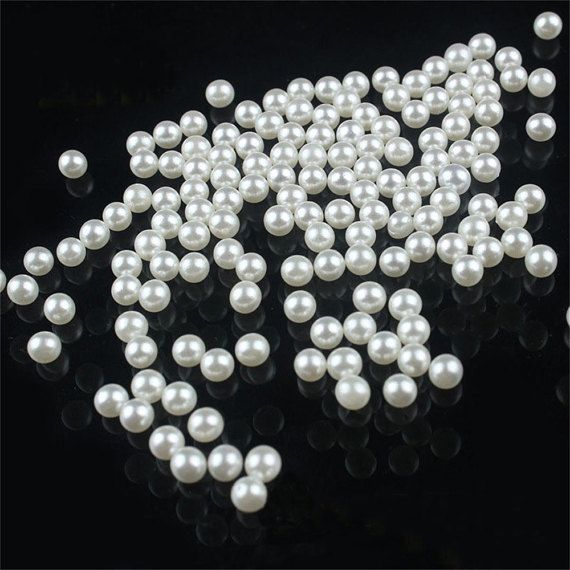 white pearls are scattered on a black surface