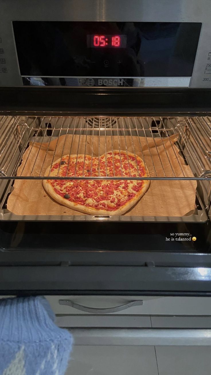 a pizza is being cooked in an oven with the time on it's display