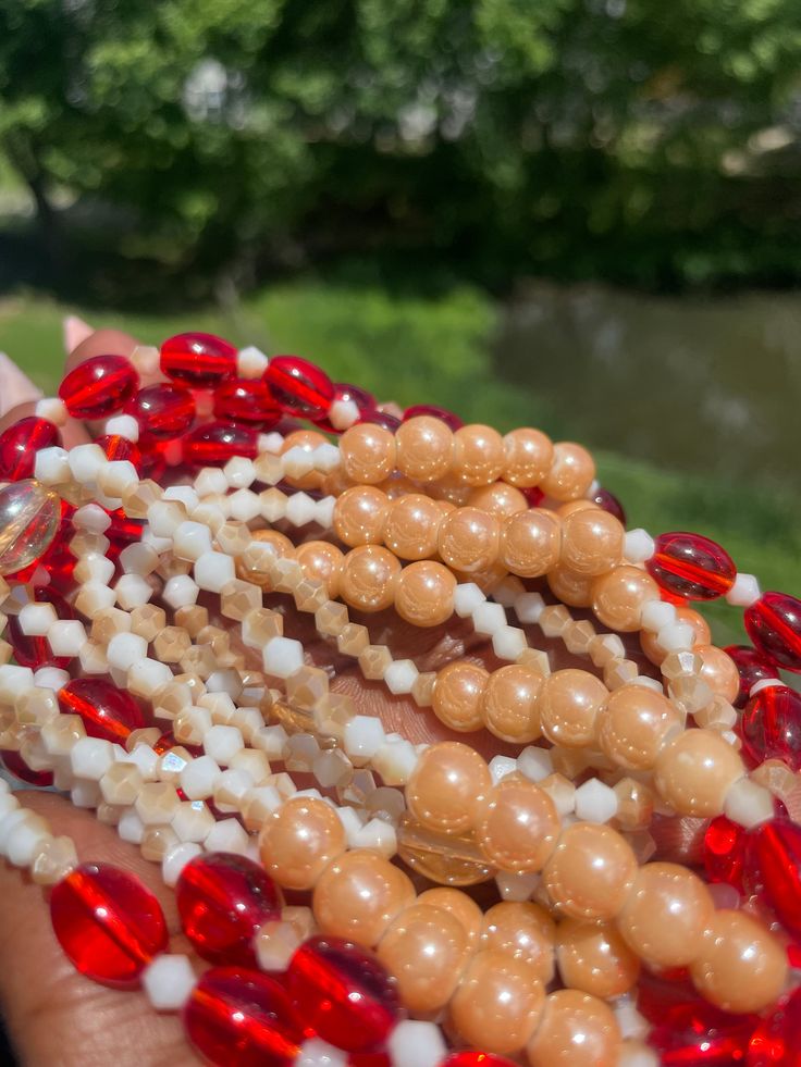 Double Strand Waist Bead "Abengourou" – an exquisite creation meticulously handcrafted with pristine white glass crystal seed beads, adorned with accents of passionate red glass seed beads. This double-strand waist bead embodies purity and elegance, offering a graceful and adjustable fit that transcends beauty and symbolism. ⚪ White Glass Crystal Seed Beads - Timeless Purity: Abengourou is adorned with pristine white glass crystal seed beads, creating an aura of timeless purity. The pristine whi White Beaded Necklace With Faceted Beads For Festive Occasions, Traditional White Jewelry With Heart Beads, Handmade Red Czech Glass Beaded Bracelets, White Glass Beaded Bracelets For Jewelry Making, White Glass Beaded Bracelets With Round Beads, Red Beaded Bracelets With Round Beads For Wedding, Red Pearl Bracelets With Round Beads, White Glass Beaded Bracelets, Pearl White Faceted Beaded Necklaces