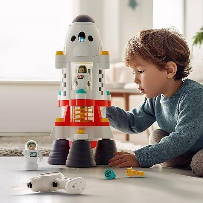 a little boy playing with a toy rocket ship