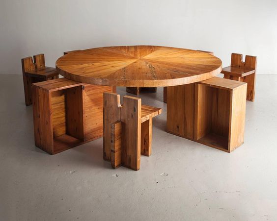 a round wooden table surrounded by cubes and chairs in an empty room with white walls