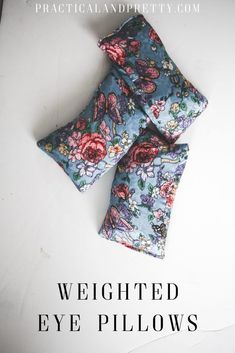 three blue and pink flowered eye pillows sitting on top of a white surface with the words, weighted eye pillows