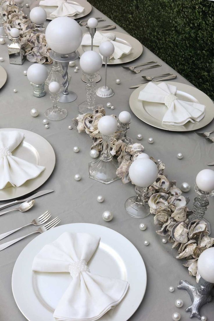 the table is set with white plates and silverware, napkins and place settings