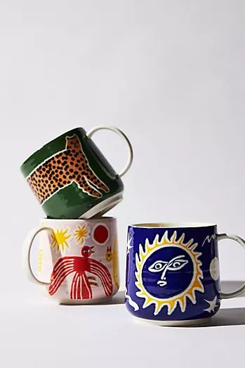 three coffee mugs with different designs on them