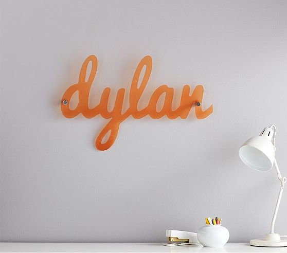 the word dyjaar is spelled in orange on a white wall next to a desk lamp