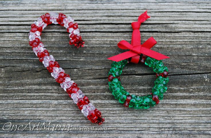 two candy canes sitting next to each other on a wooden surface with the word christmas spelled out