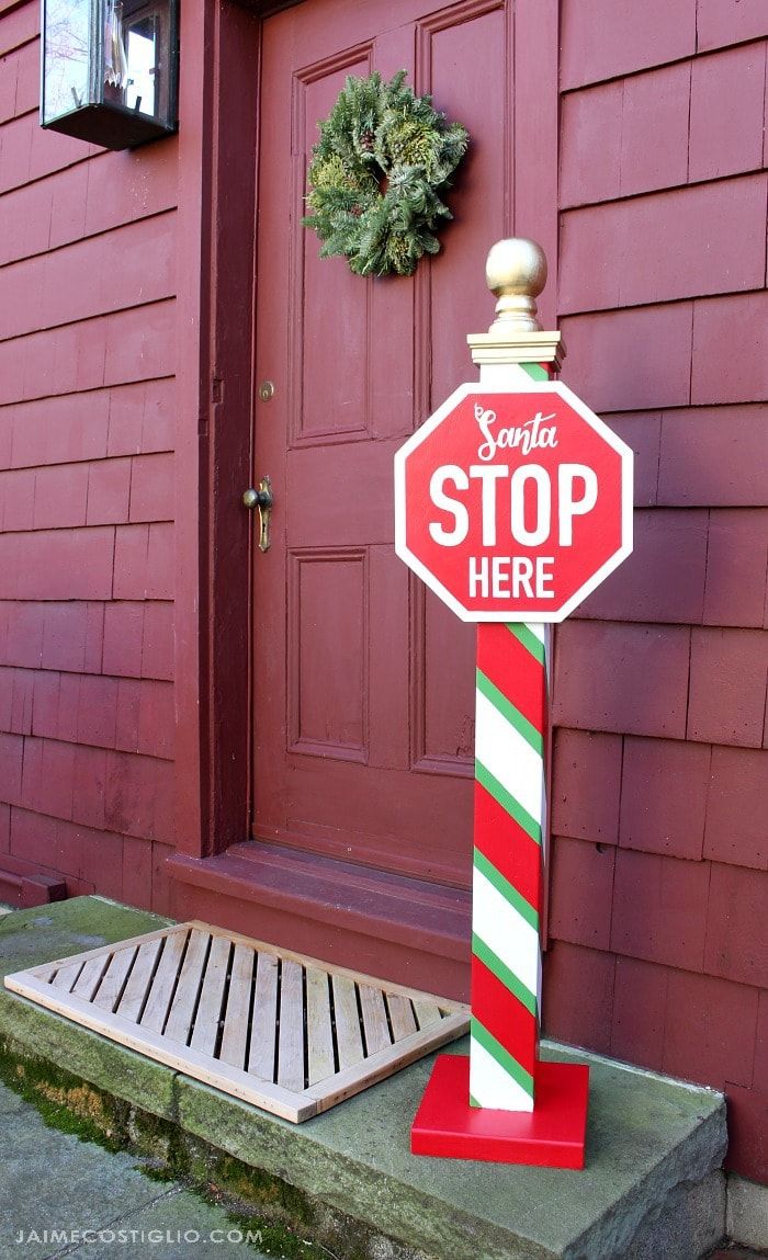 a red stop sign sitting on top of a green and white pole next to a door