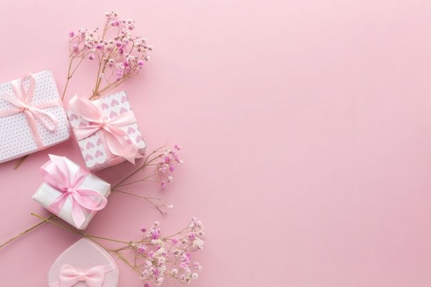 pink and white gift boxes with bows on them next to baby's breath flowers