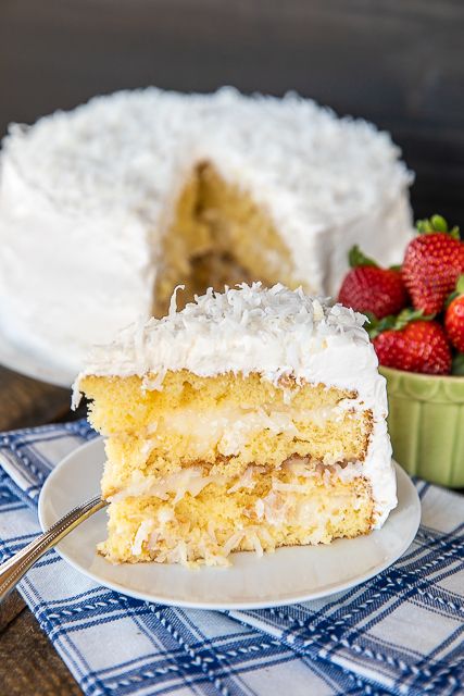 a piece of cake on a plate next to a bowl of strawberries