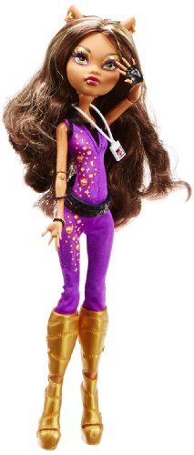 a doll with long brown hair and purple outfit holding her hand up in the air