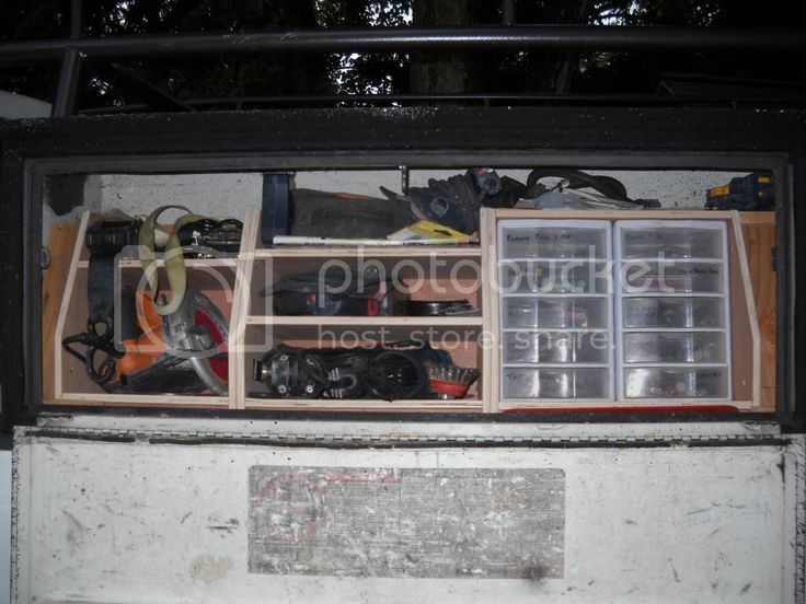 the inside of a truck with tools and other items in it's storage compartment