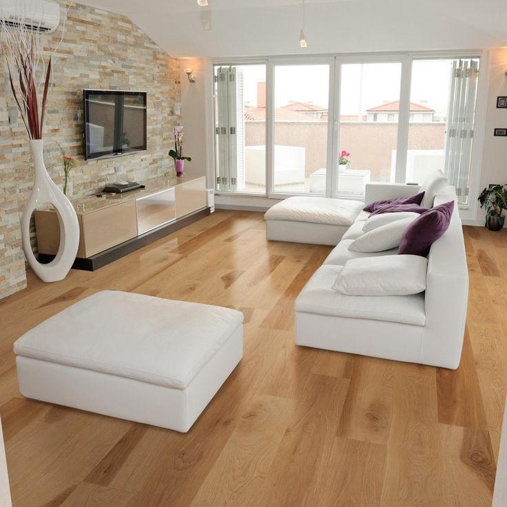 a living room filled with furniture and a flat screen tv on top of a wooden floor