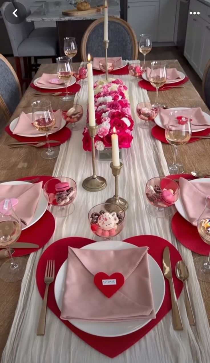 the table is set for valentine's day with pink and red decorations