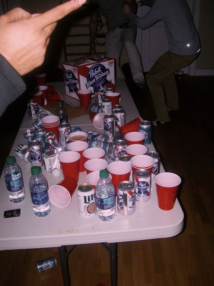 a table topped with lots of cups filled with water and sodas on top of it