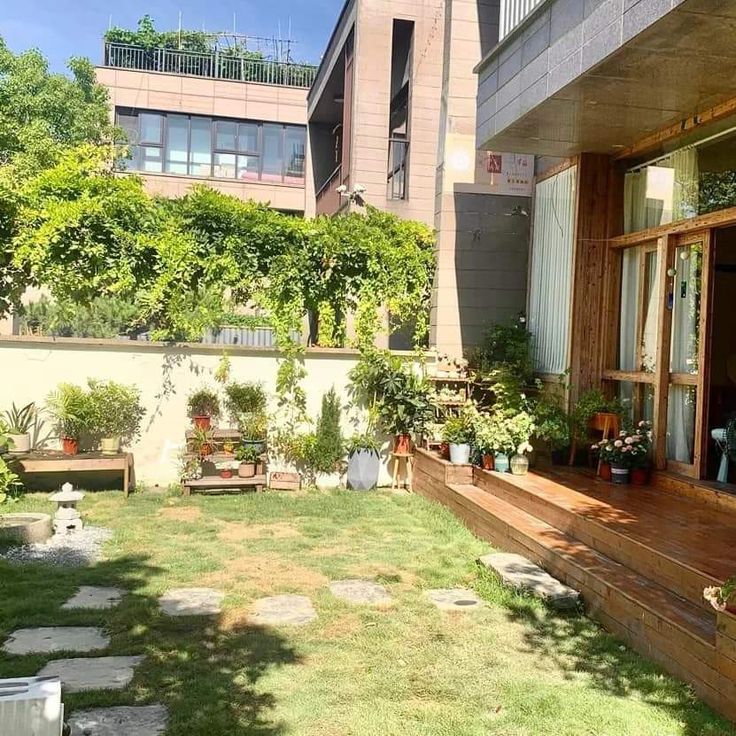 an outside view of a house with some plants on the deck and in the back yard