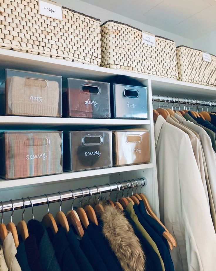 an organized closet with clothes and baskets on the shelves, including shirts and pants hanging in bins