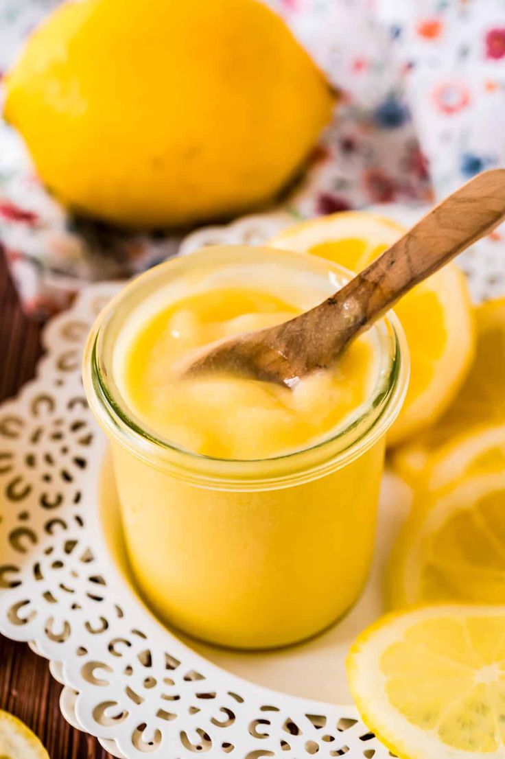 lemon curd in a glass jar with a wooden spoon