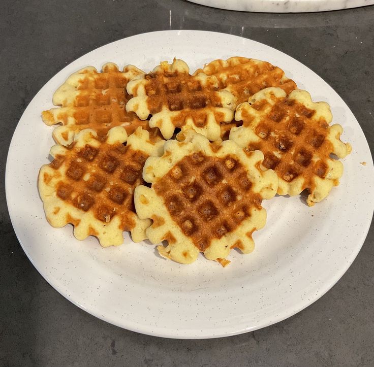 four waffles are arranged on a white plate