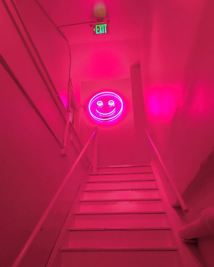 the stairs are lit up with bright pink lights and smiley faces on them, as well as an exit sign