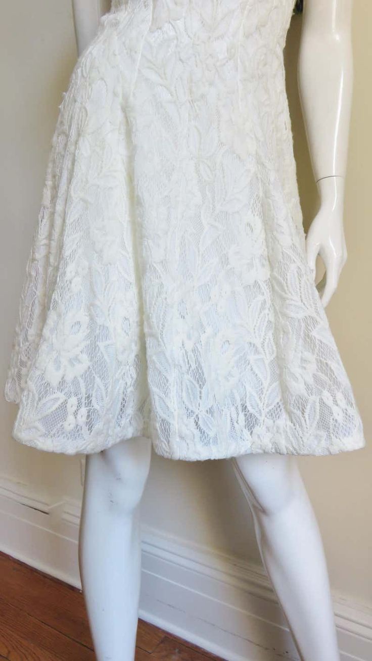 For Sale on 1stDibs - A gorgeous dress from Nina Ricci in white lace. From the front it is a simple V neck sleeveless A line dress in white lace. The back cut out from below Formal A-line Lace Dress With Lace Bodice, Formal Fit And Flare Lace Dress With Lace Trim, White A-line Lace Dress With Lace Patchwork, Fitted A-line Lace Dress, A-line Scalloped Lace Cocktail Dress, Cocktail A-line Lace Dress With Scalloped Lace, Cocktail A-line Scalloped Lace Dress, Spring Cocktail Dress With Delicate Lace, Delicate Lace A-line Dress