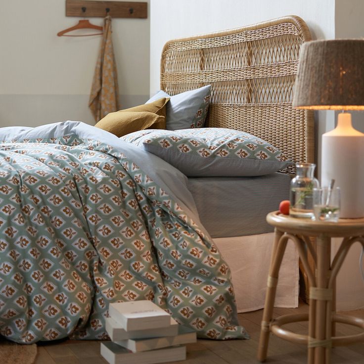 a bed with pillows and blankets on top of it in a bedroom next to a table