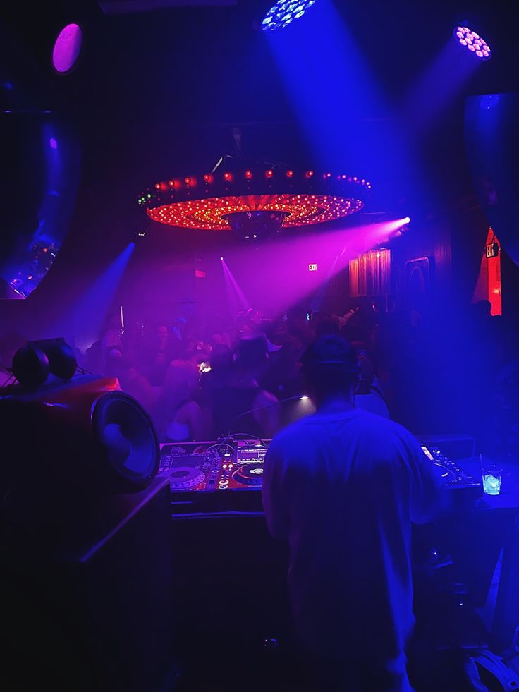 a dj mixing in front of purple and blue lights