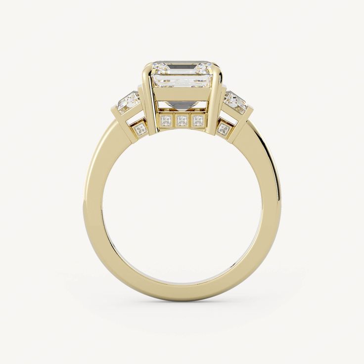 a three stone engagement ring with diamonds on the shoulders and side stones in yellow gold