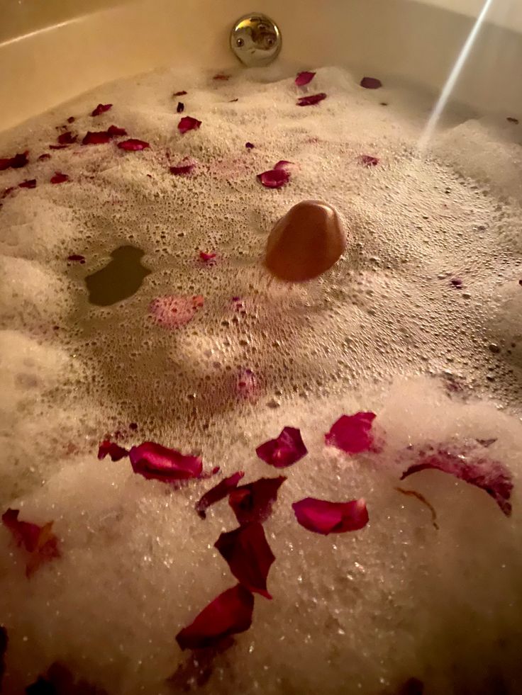 a bathtub filled with foam and rose petals