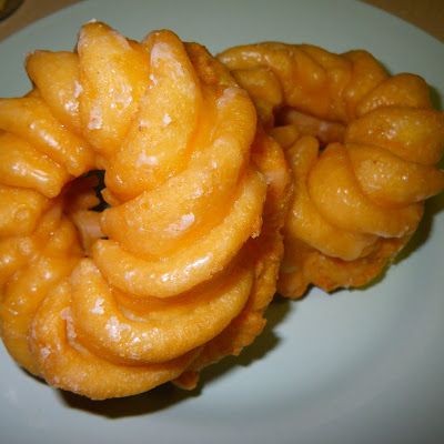 two donuts on a white plate sitting on a table