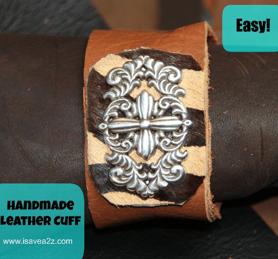 a brown leather cuff with an ornate design on the clasp and handmade leather cuff