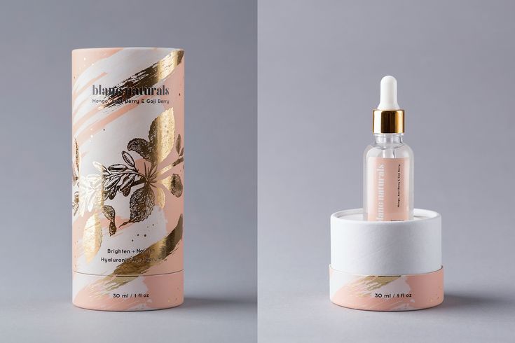 an empty bottle next to a white container with pink flowers on it and gold accents