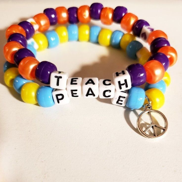 two bracelets with words and charms that say teach peace