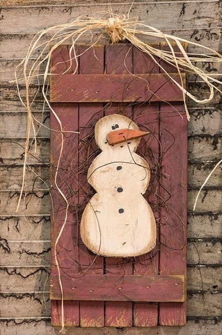 a wooden snowman hanging on the side of a building