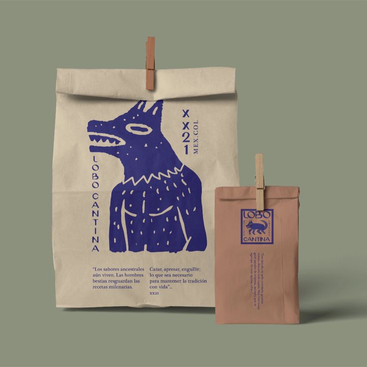 a brown bag with a blue dog on it next to a pink paper bag that says,