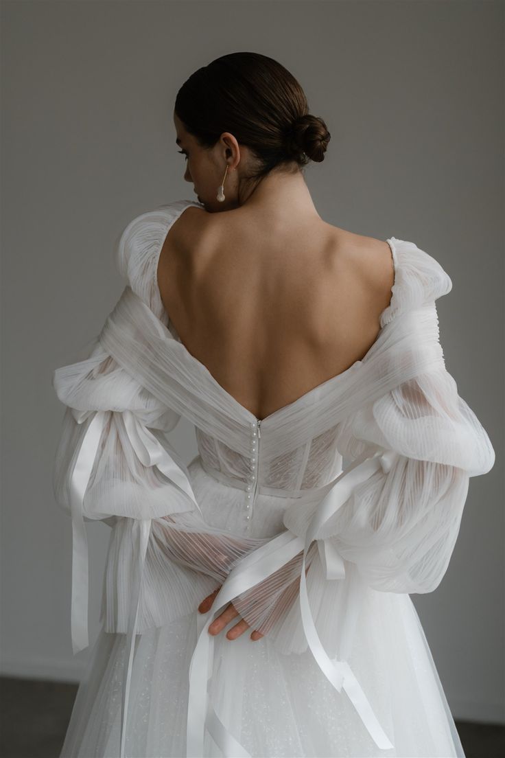 the back of a woman's dress with sheer white ruffles on it