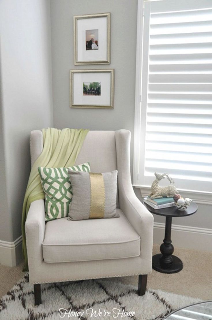 a living room with a chair and pictures on the wall