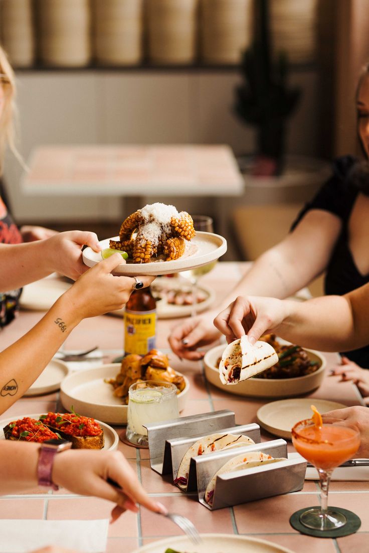 a group of people sitting around a table eating food