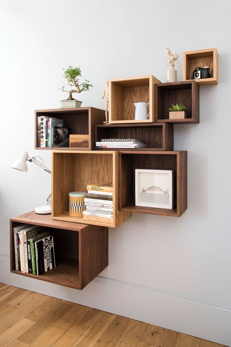 a bookshelf filled with lots of books next to a white vase and plant