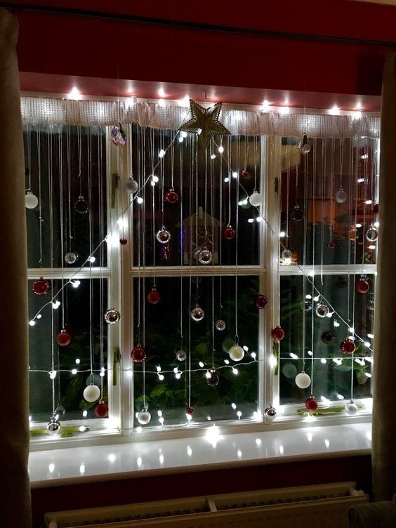 a window with christmas lights and ornaments on it