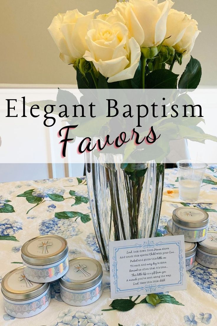 a table topped with white roses and jars filled with candles next to a vase full of flowers