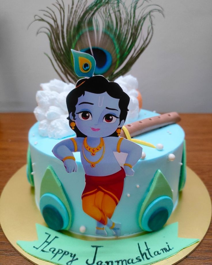 there is a birthday cake decorated with an image of a boy on it and peacock feathers