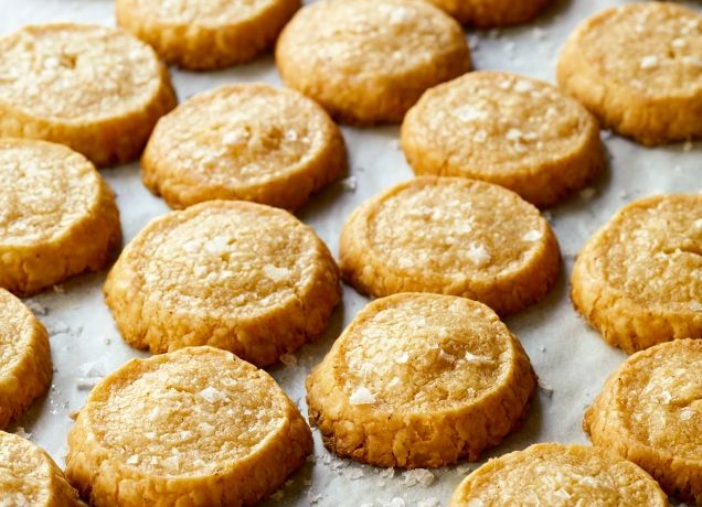 some cookies that are sitting on top of a sheet of wax paper and ready to be eaten